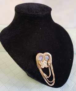 Arany színű, két gombos, lánc-soros melltű